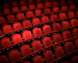 plush red chairs in an empty theatre, a photo by Benjamin Thompson